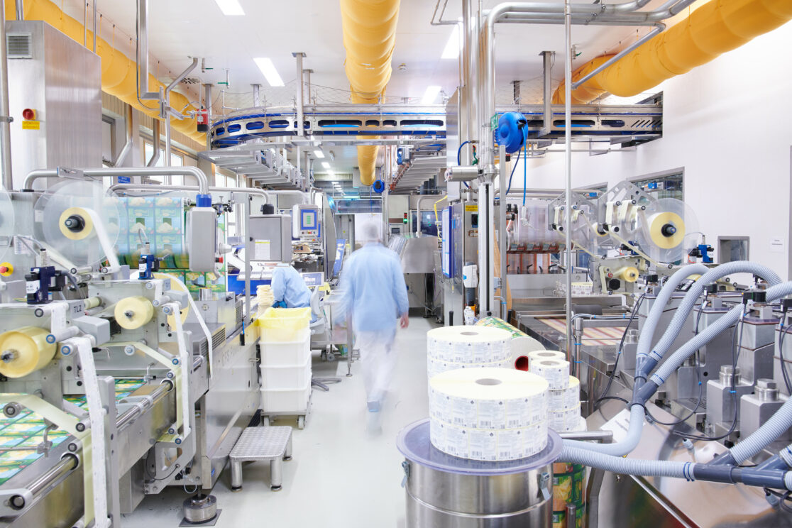 Verpackungsanlagen und Mitarbeitende in einem Produktionsbereich