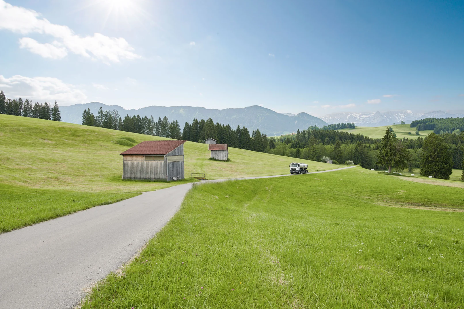 Milchsammelwagen auf einer kleinen Landstraße in der Allgäuer Voralpenlandschaft