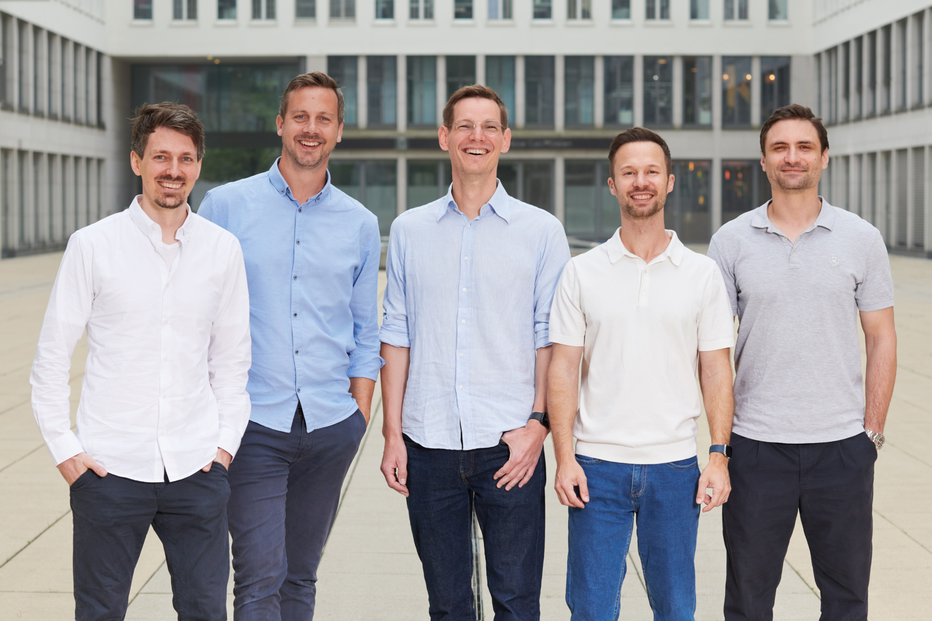 Fünfköpfiges Führungsteam von casavi und managbl.ai gemeinsam vor moderner Bürofassade