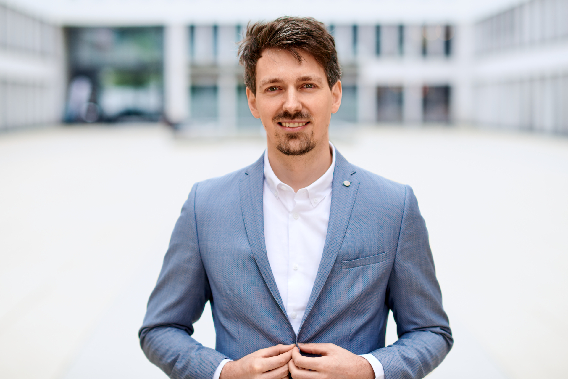 Oliver Stamm im Businessporträt vor moderner Bürofassade