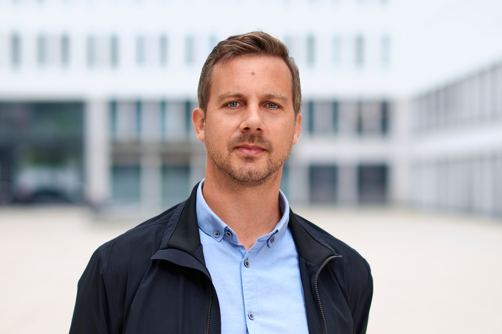 Peter Schindlmeier vor unscharfer Architekturfassade