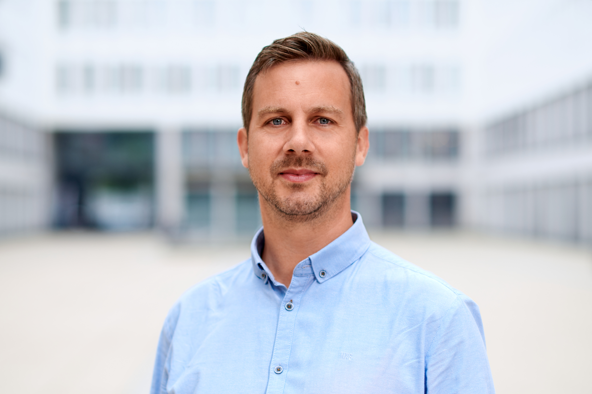 Peter Schindlmeier im hellblauen Hemd mit direktem Blick in die Kamera, Businessfoto in München
